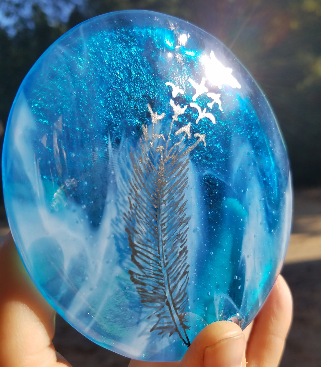 close up feather flying suncatcher in blue Celebration of life Funeral Memorials. Ashes in Glass Cremation Glass Art Sculptures, Cremation Wind Chimes, Cremation Sun Catchers, Table Displays, & Cremation Jewelry Custom USA Handmade by Infusion Glass. Ashes Infused Glass Human and Pet Cremation Ash Urns  Ashesinfusedglass.com